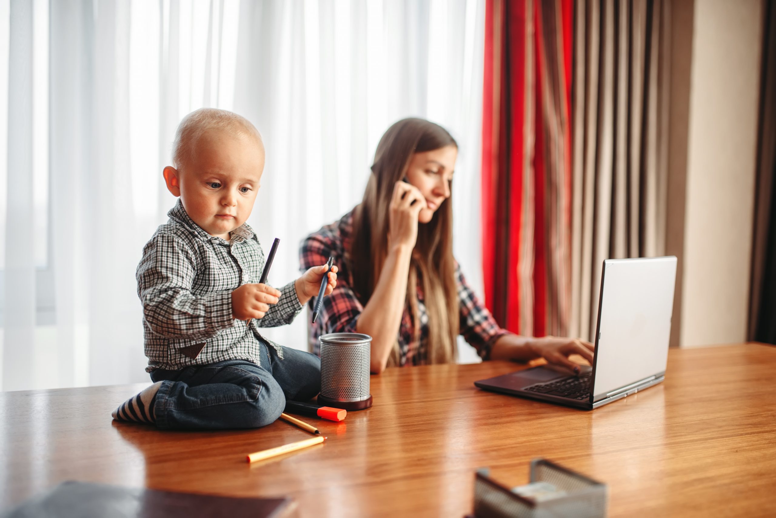 Mother works at home little kid helps her